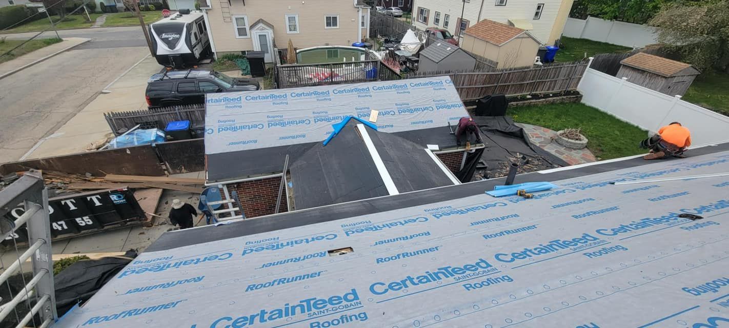 A group of people are working on the roof of a house.