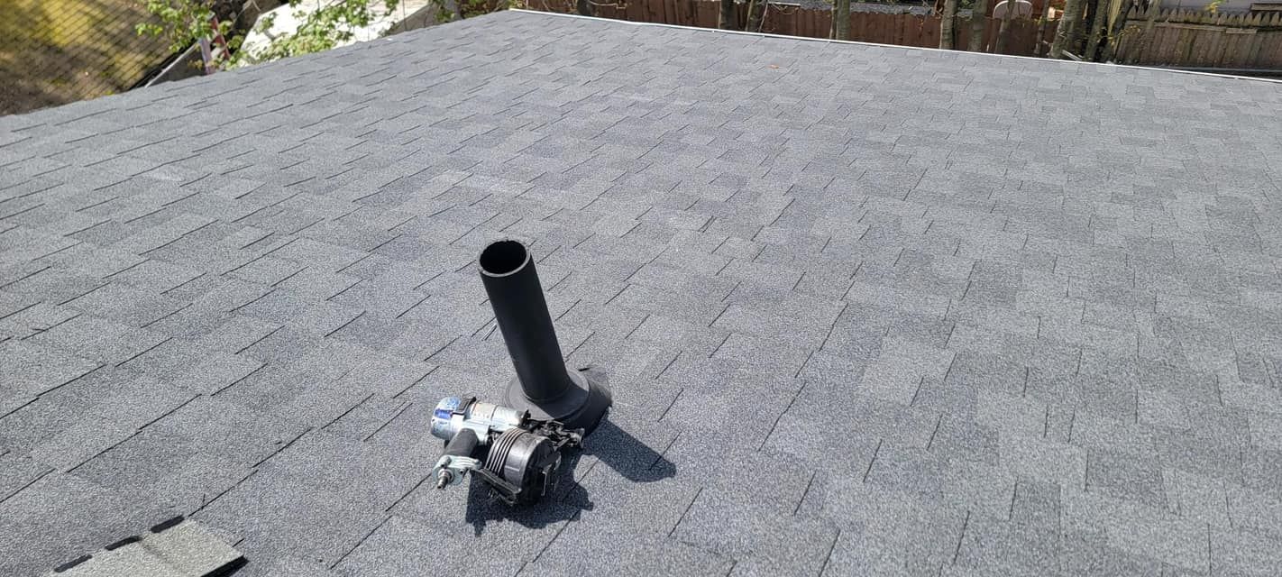A black pipe is sitting on top of a roof.
