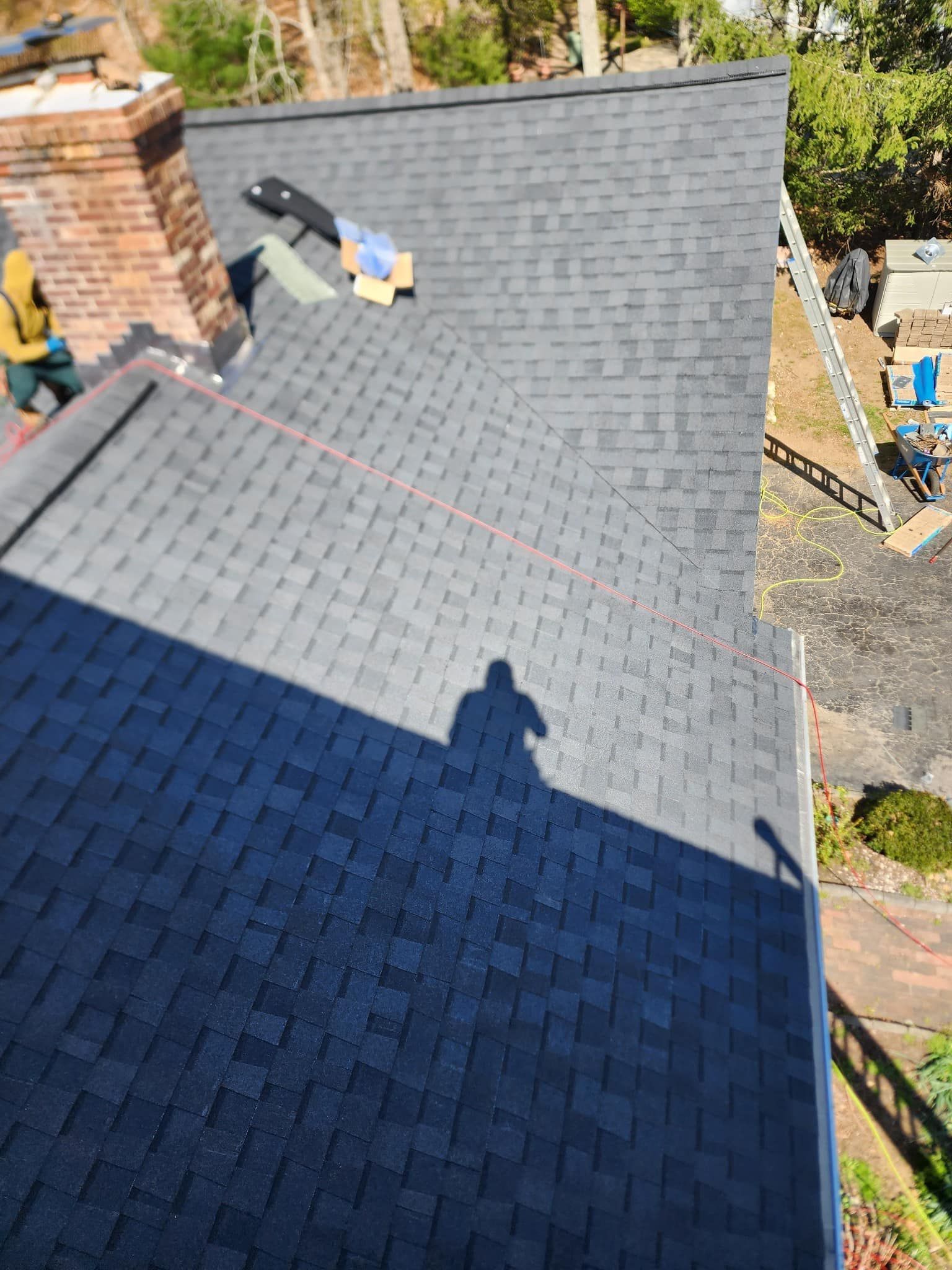 A man is working on the roof of a house.