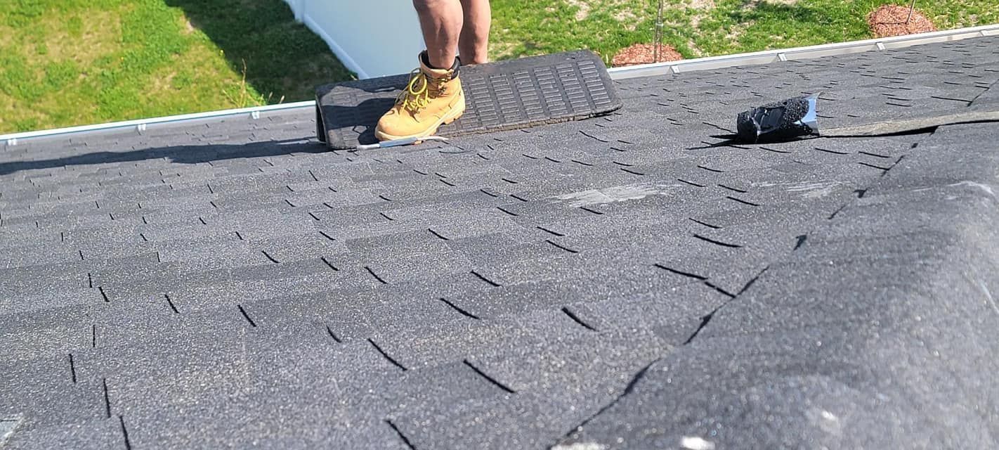A person is standing on top of a roof.