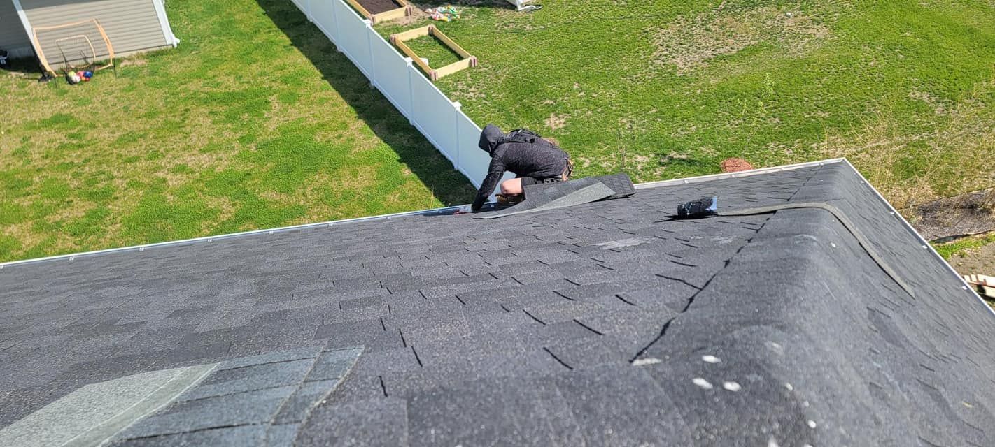 A man is working on the roof of a house.