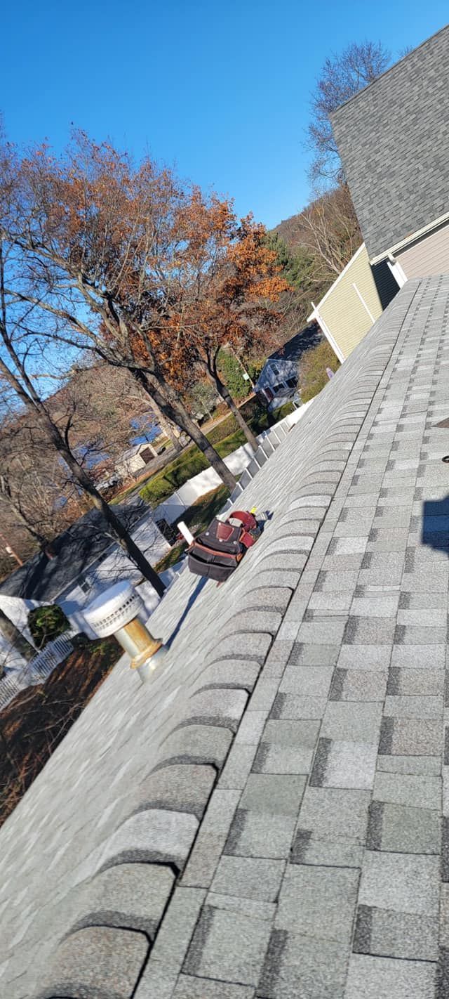 A person is standing on the roof of a house.