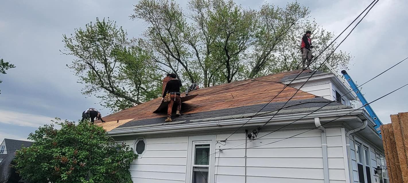 Two men are working on the roof of a house.