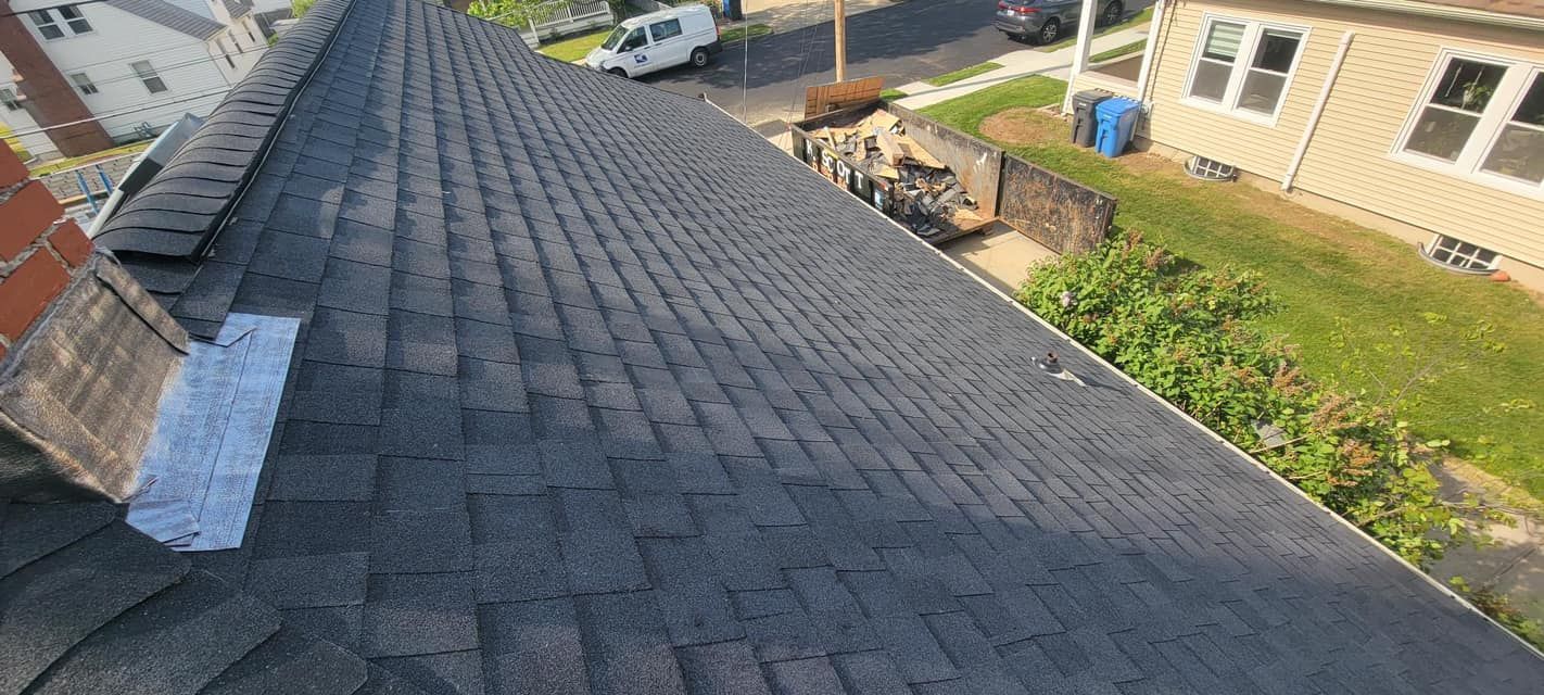 An aerial view of a roof with shingles and a chimney.