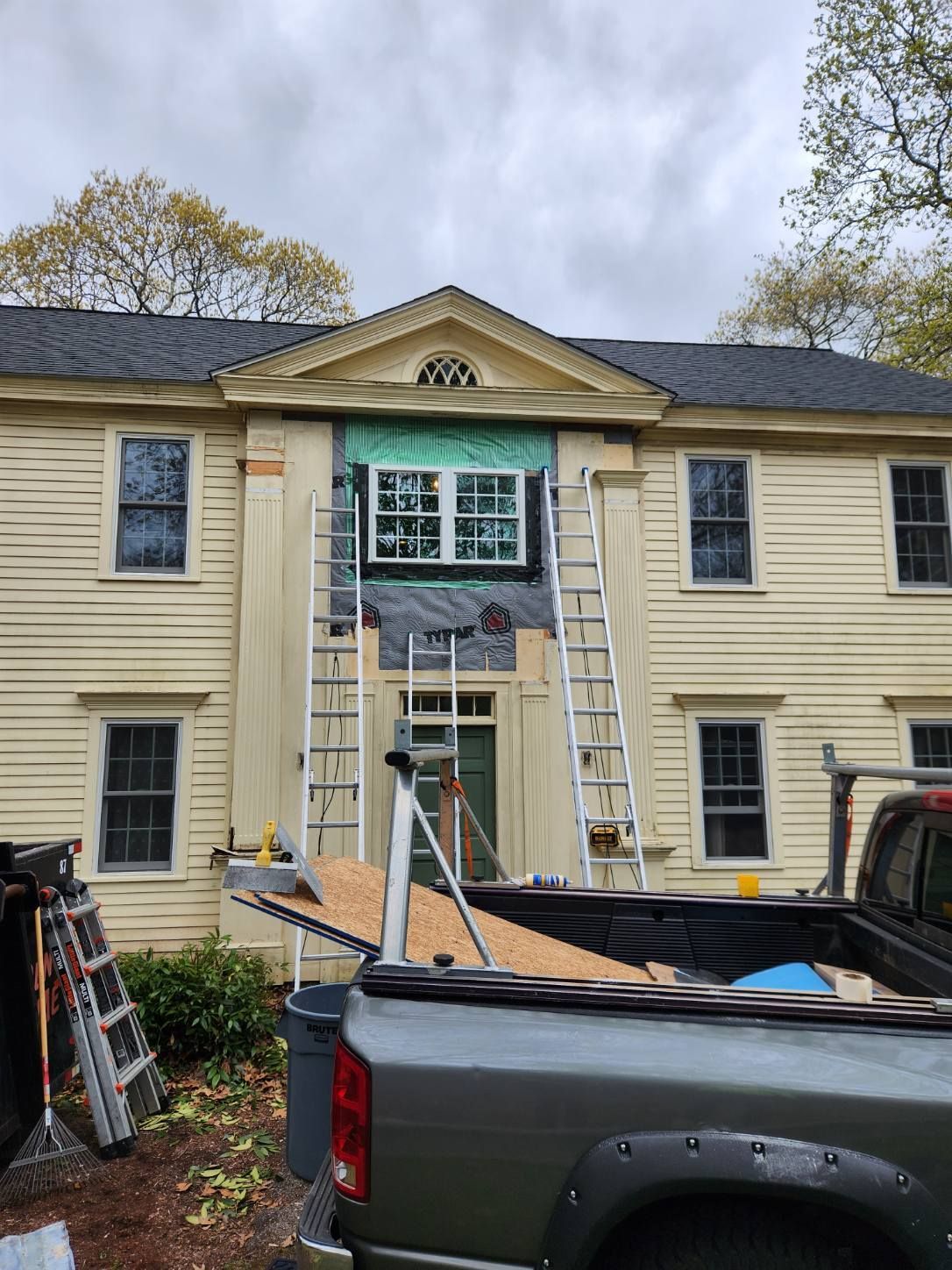 A truck is parked in front of a house under construction.