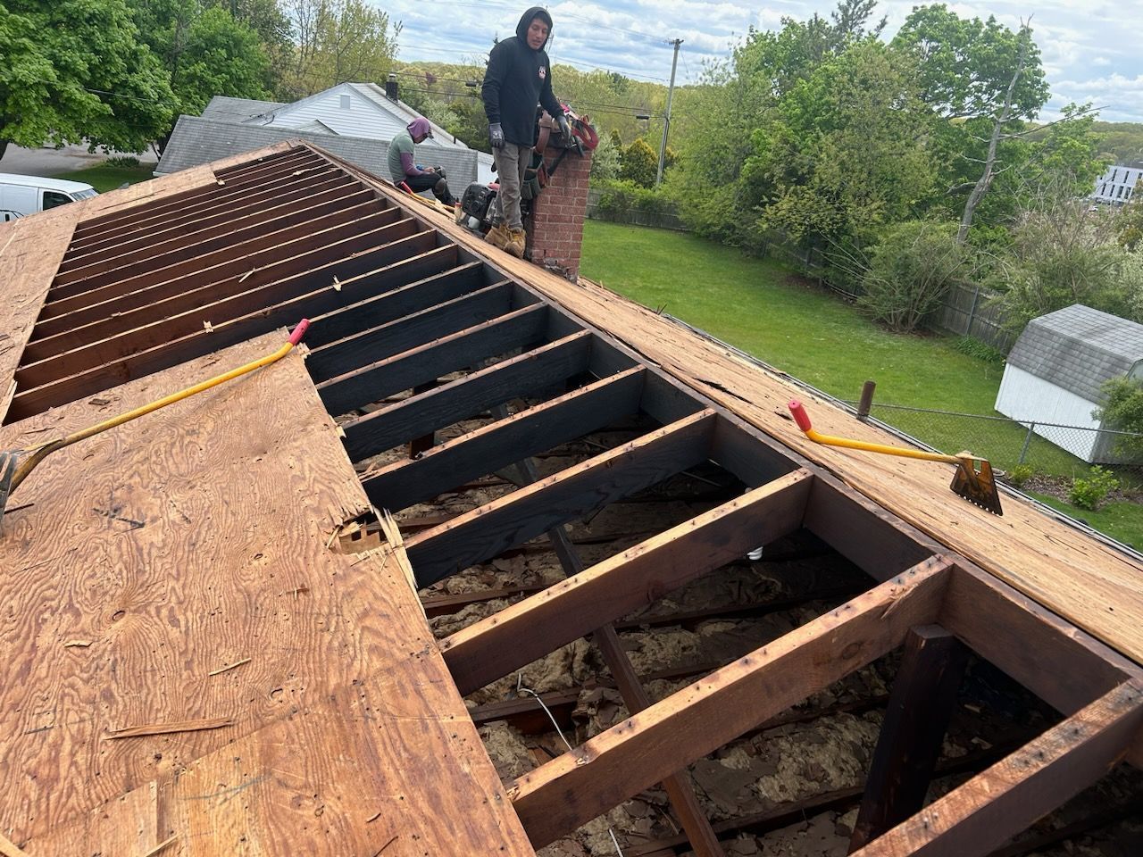 A man is working on the roof of a house.