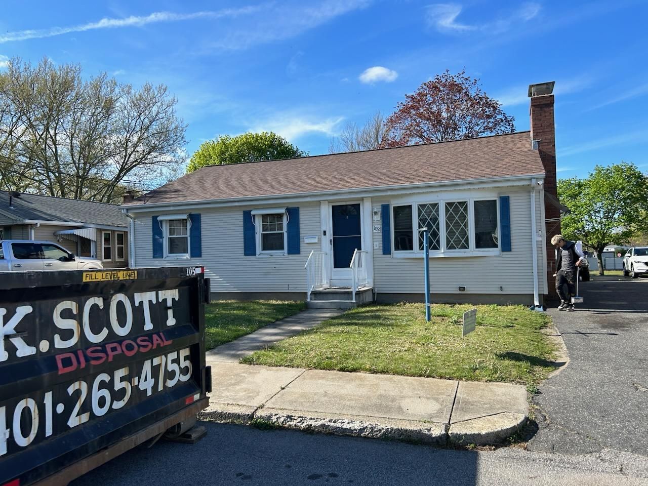 A dumpster is parked in front of a house.