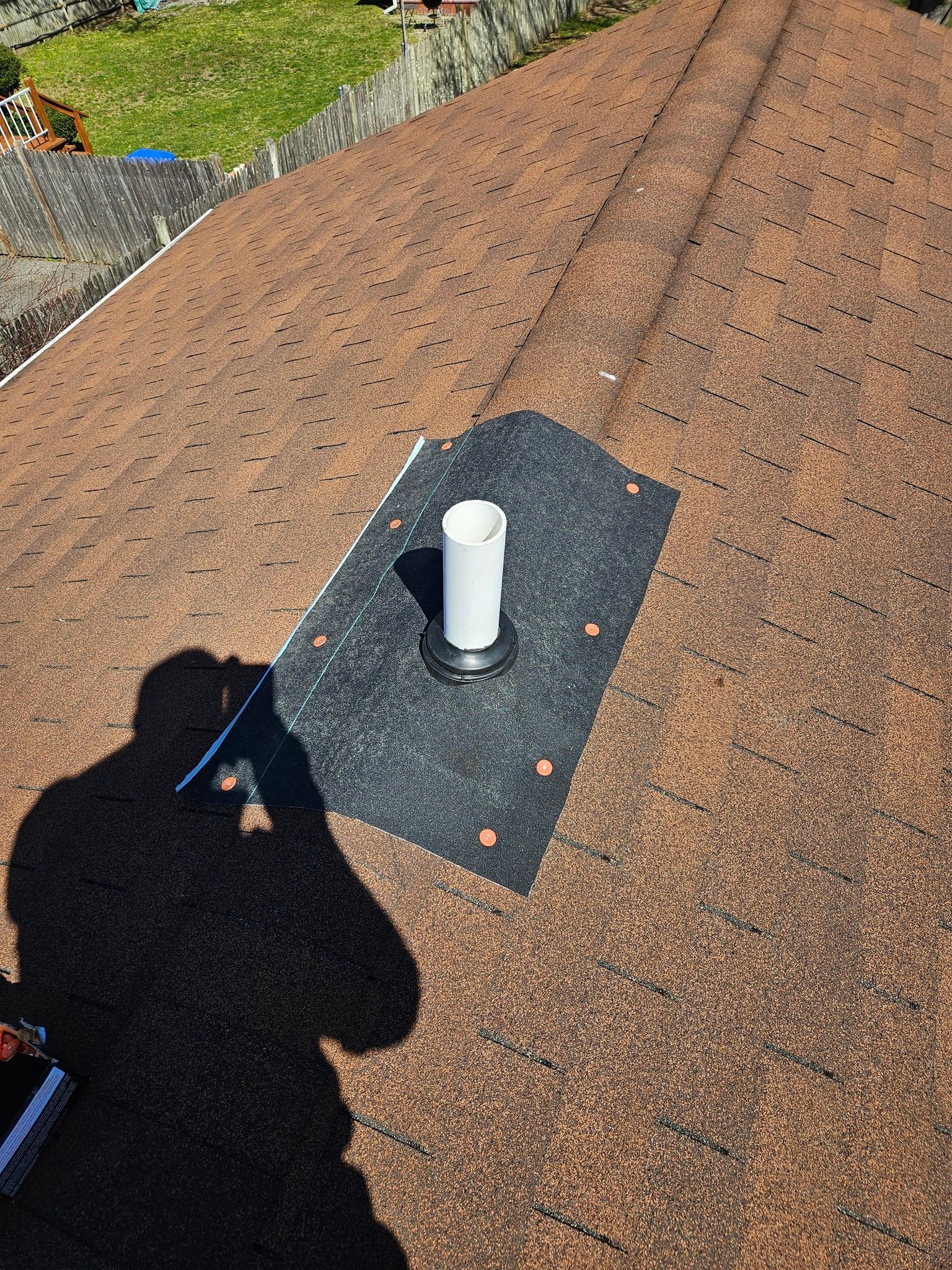 A white pipe is sitting on top of a roof.