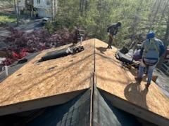 A group of men are working on a roof.