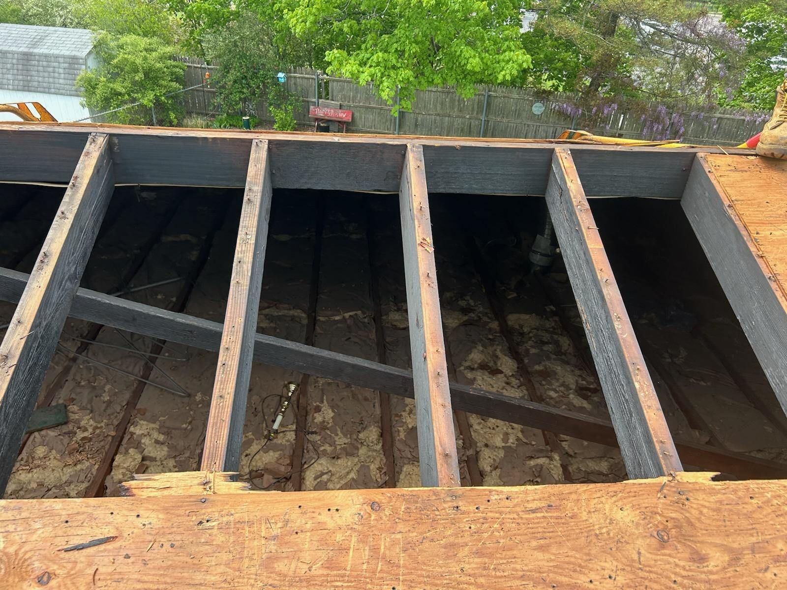 A roof is being built with wooden beams and a metal frame.