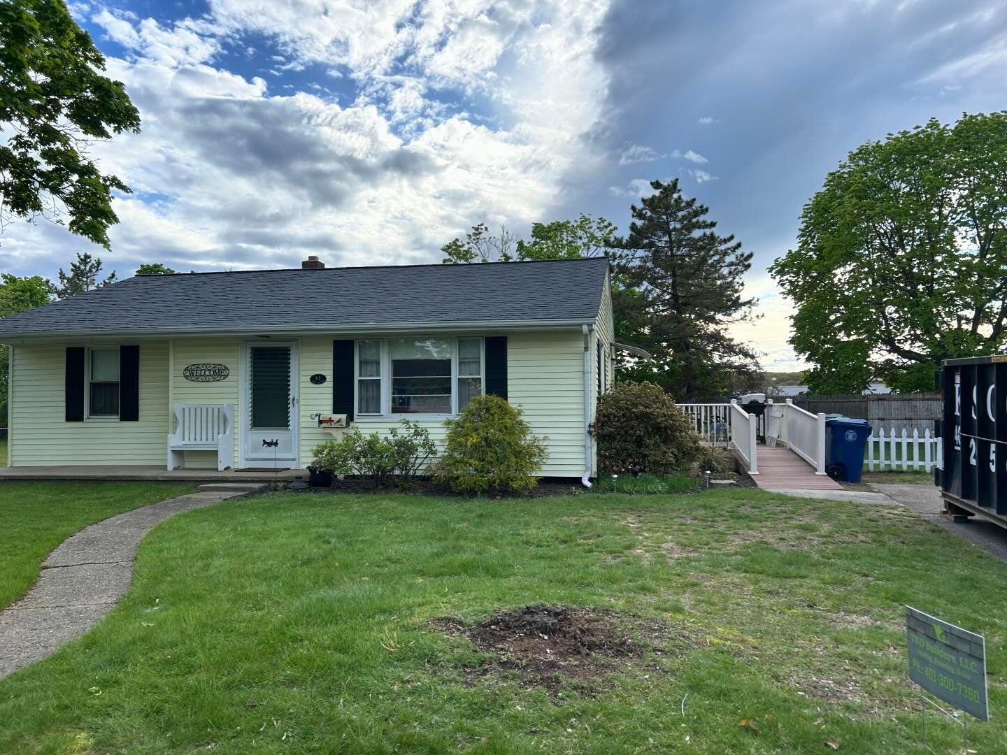 A white house with a gray roof and black shutters