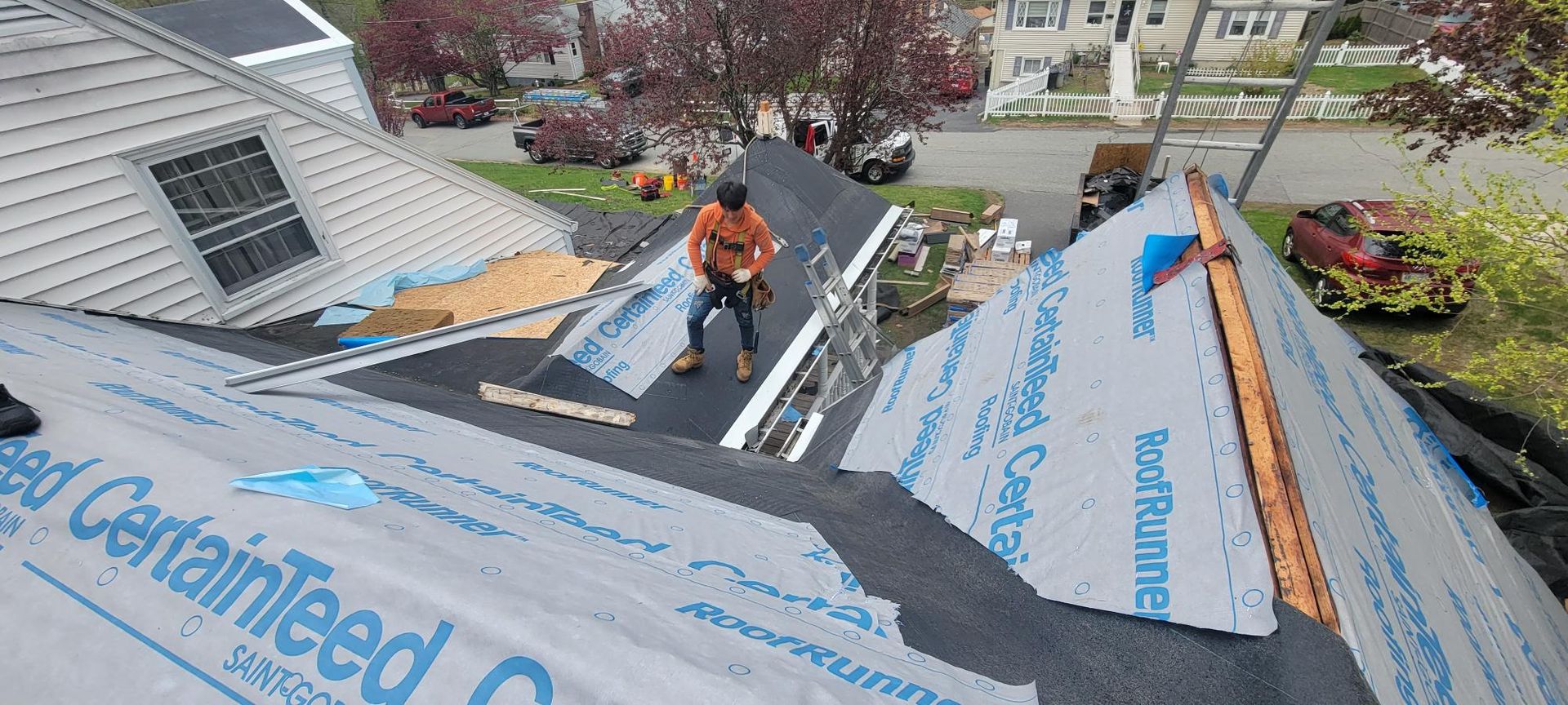 A man is working on the roof of a house.