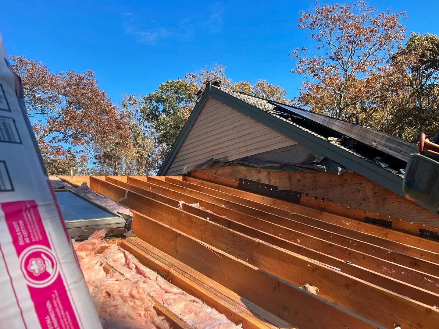 A roof is being built with wooden beams and insulation.