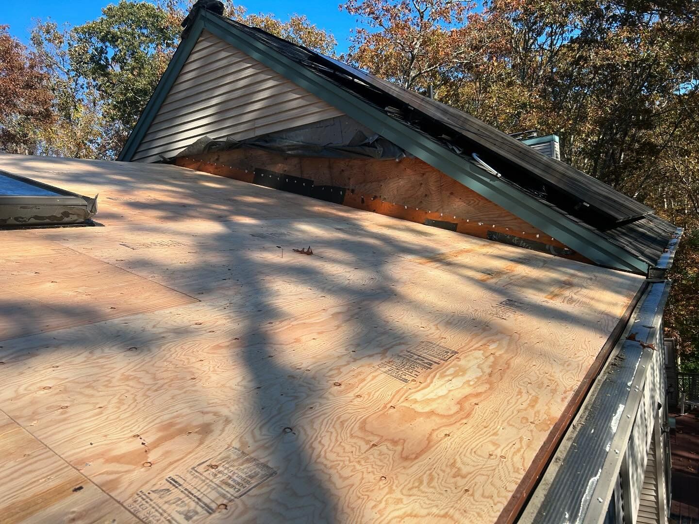 The roof of a house is being remodeled and the roof is covered in plywood.