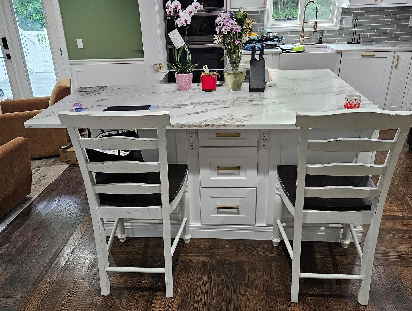 A kitchen with a table and chairs and a marble counter top.