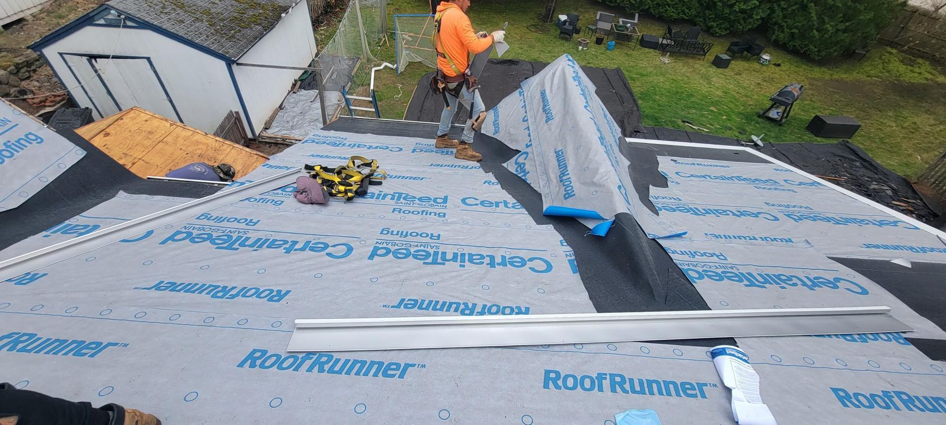 A man is working on the roof of a house.