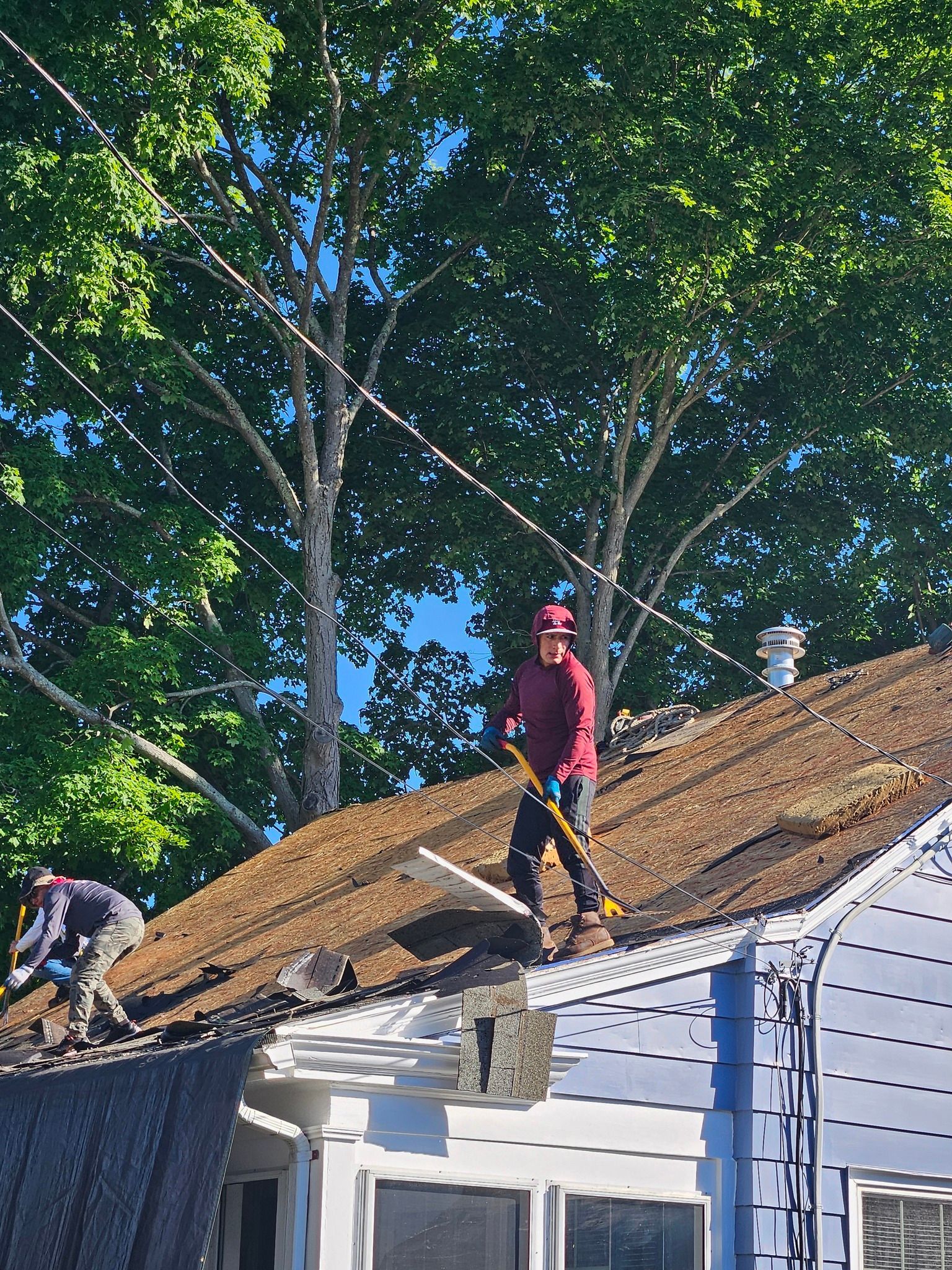 Two men are working on the roof of a house.