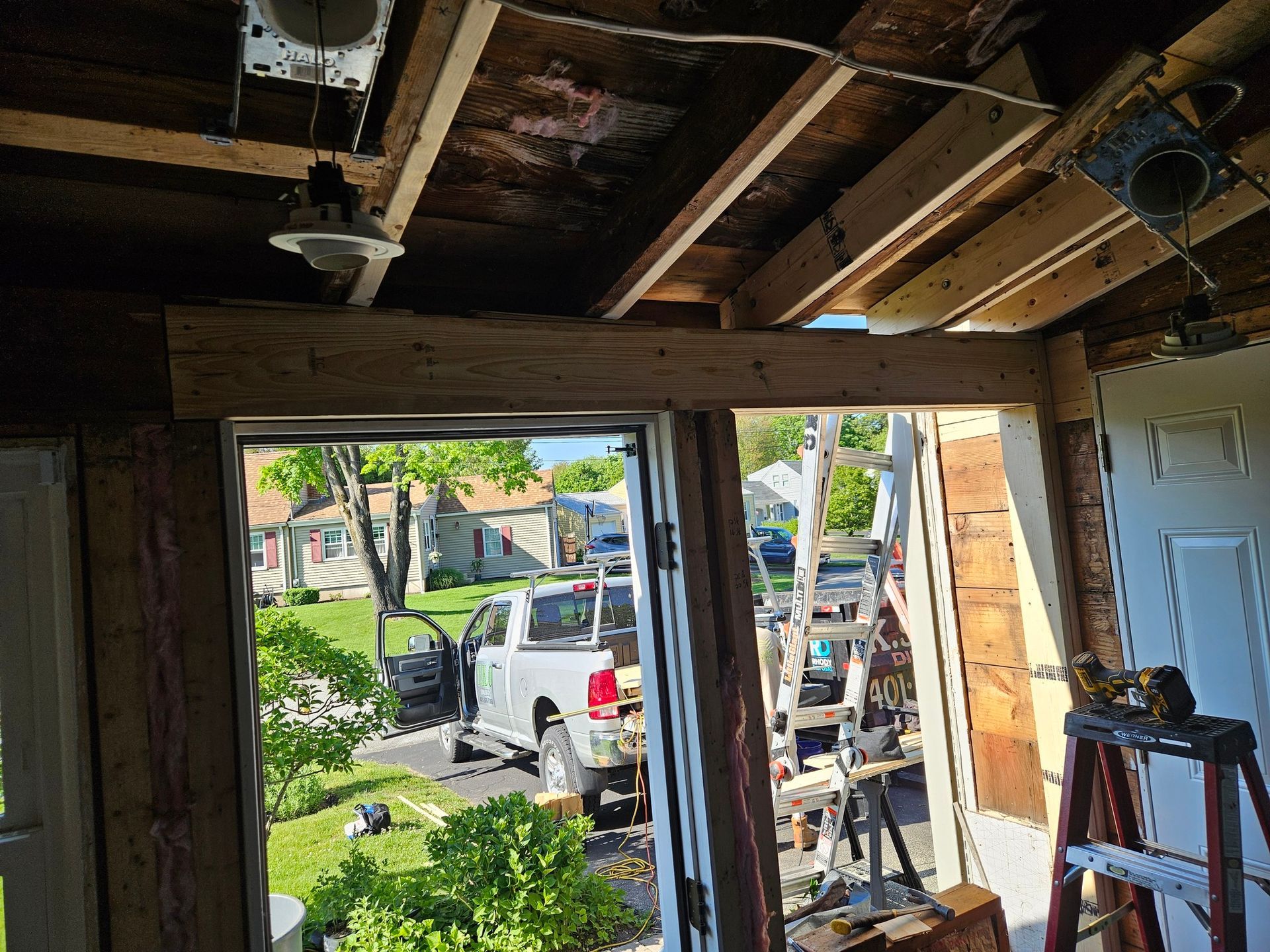 A room with a window and a ladder in it is being remodeled.