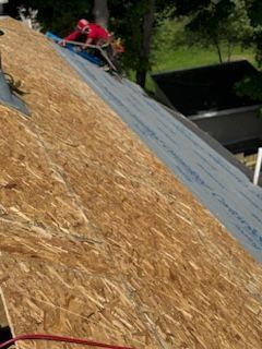 A man is working on the roof of a house.