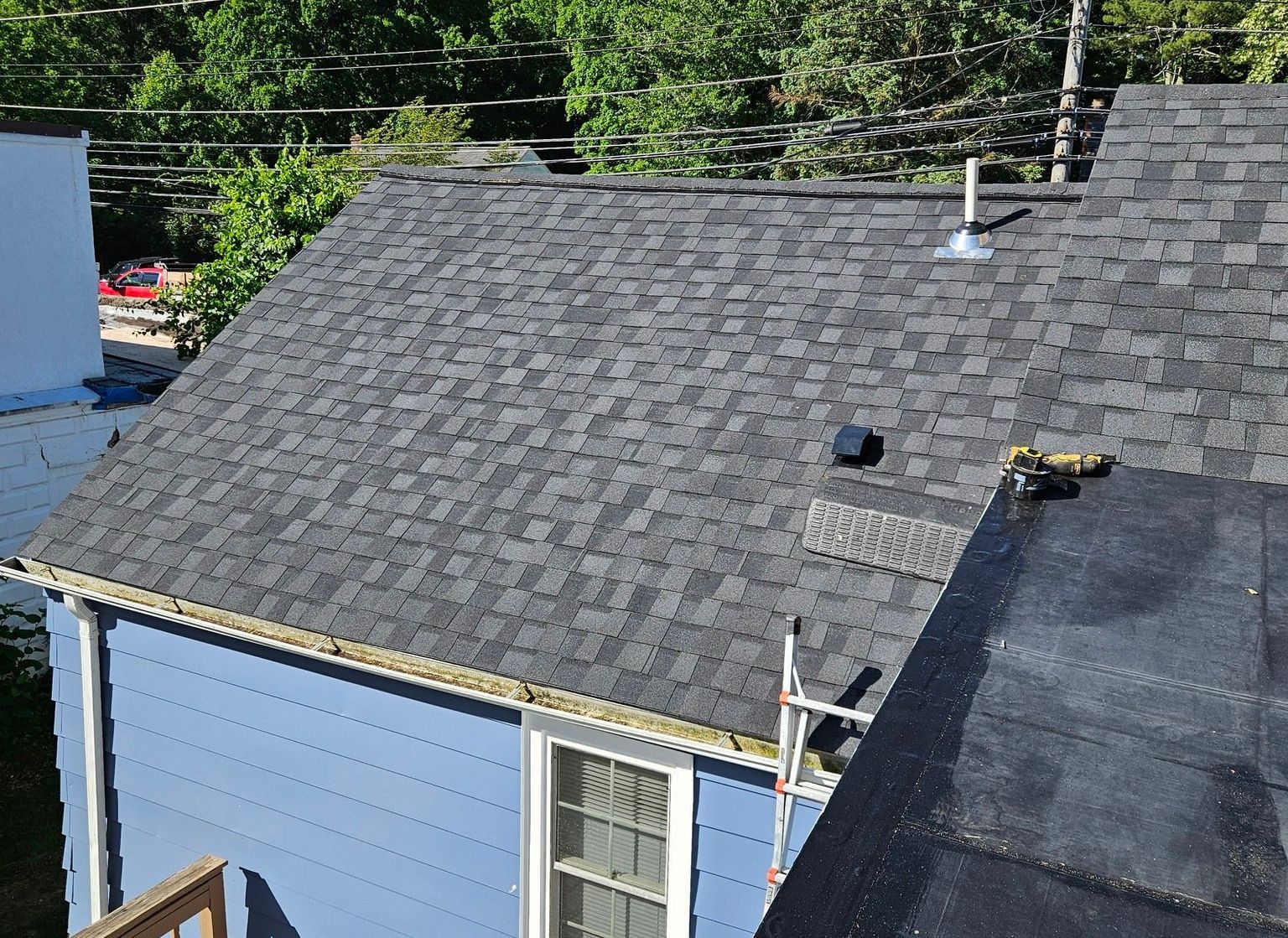 A blue house with a black roof and a chimney.
