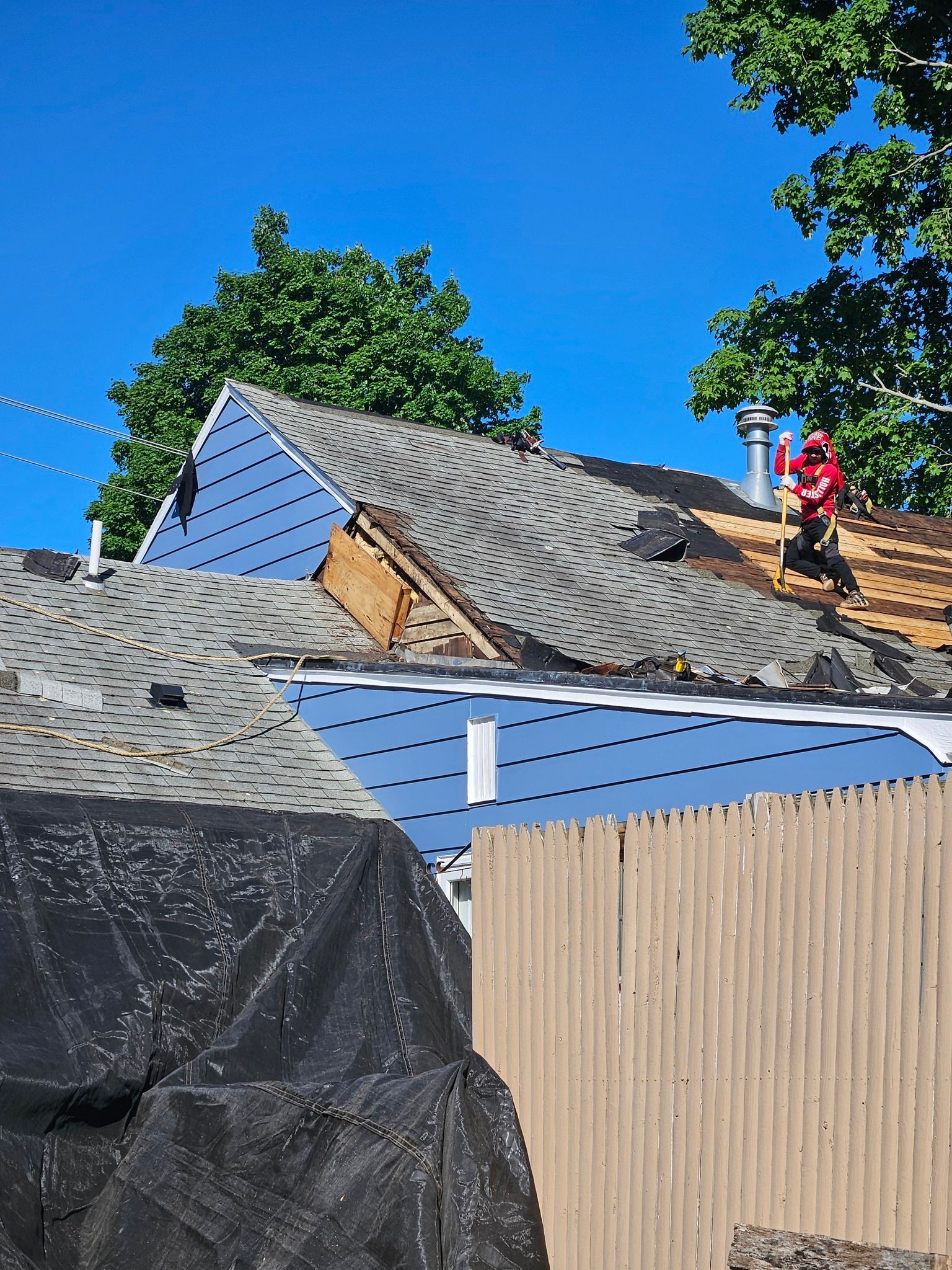 A man is working on the roof of a house.