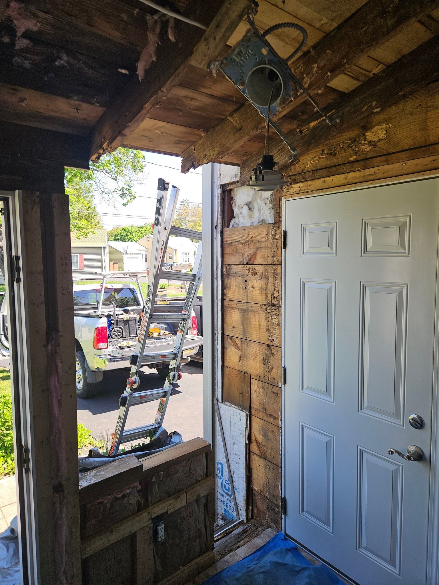 A ladder is hanging from the ceiling of a building next to a door.