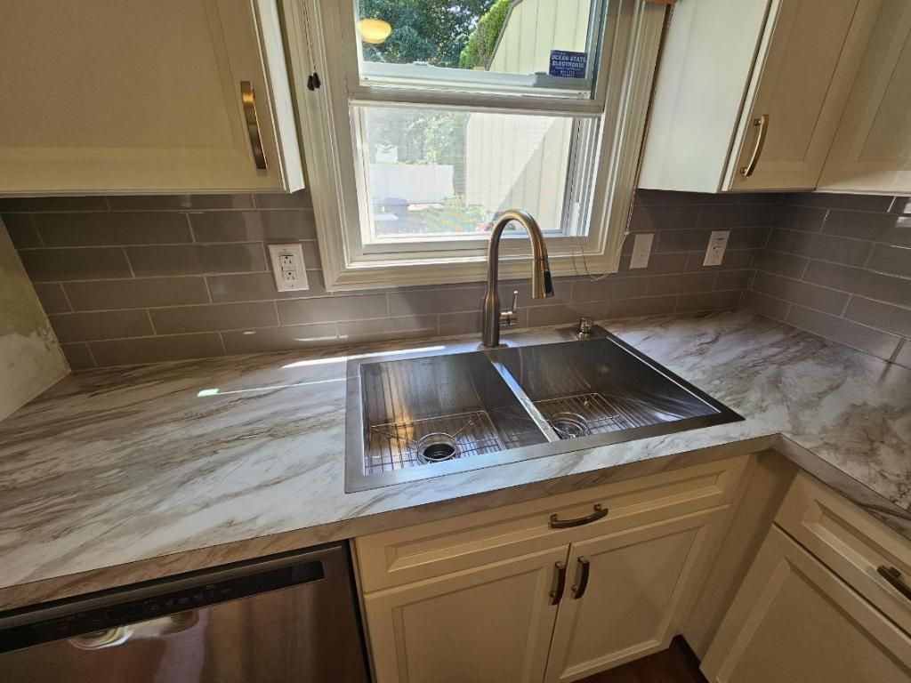 A kitchen with a stainless steel sink and a window.