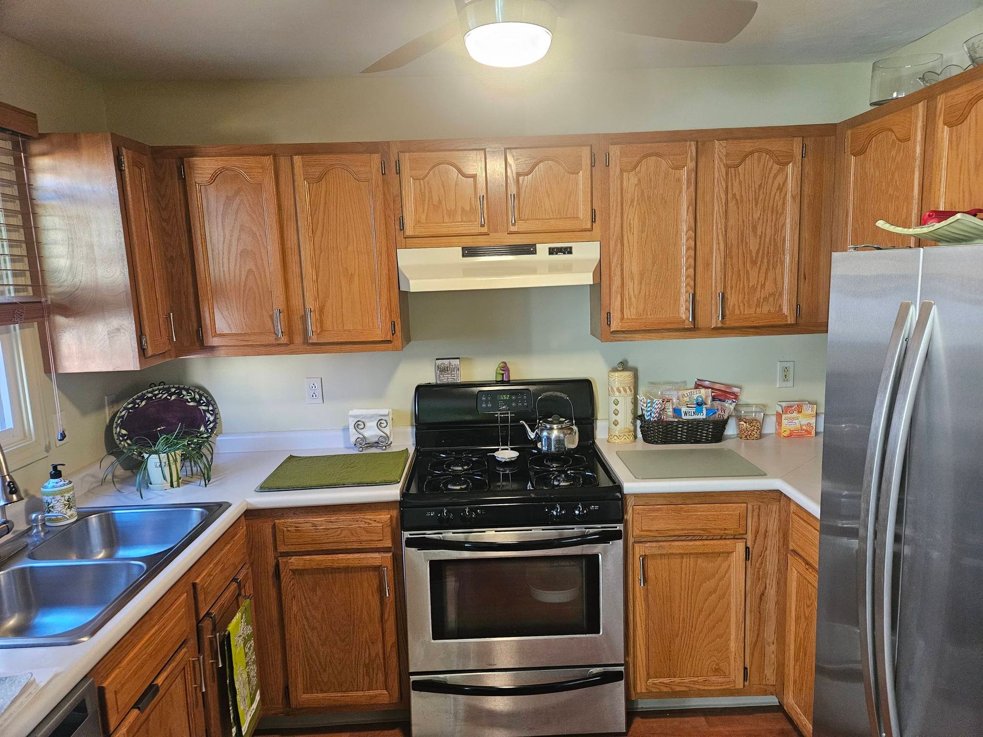 A kitchen with stainless steel appliances and wooden cabinets.