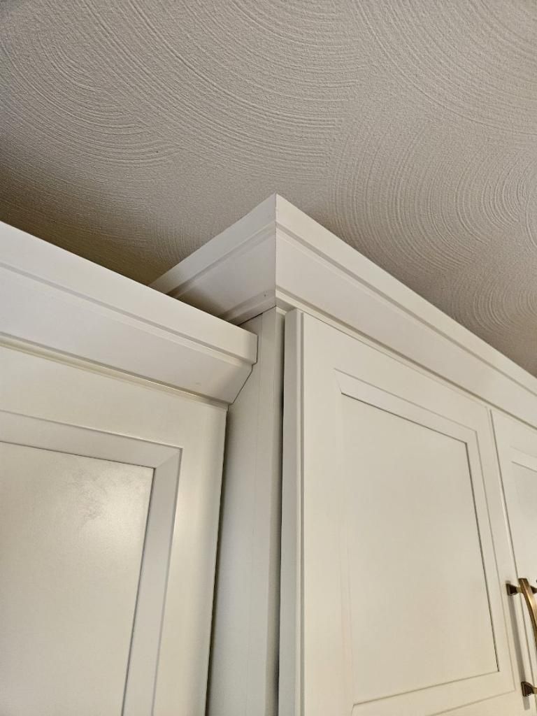 A kitchen with white cabinets and a ceiling.