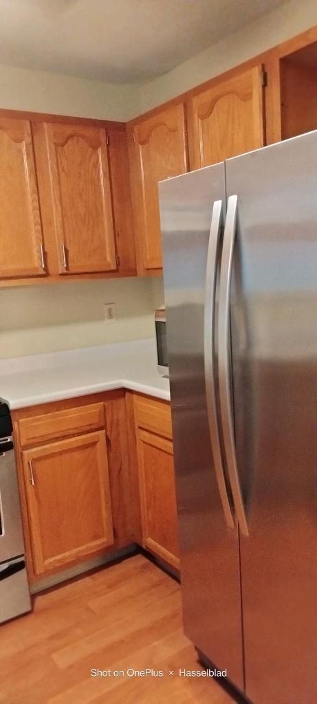 A kitchen with stainless steel appliances and wooden cabinets.
