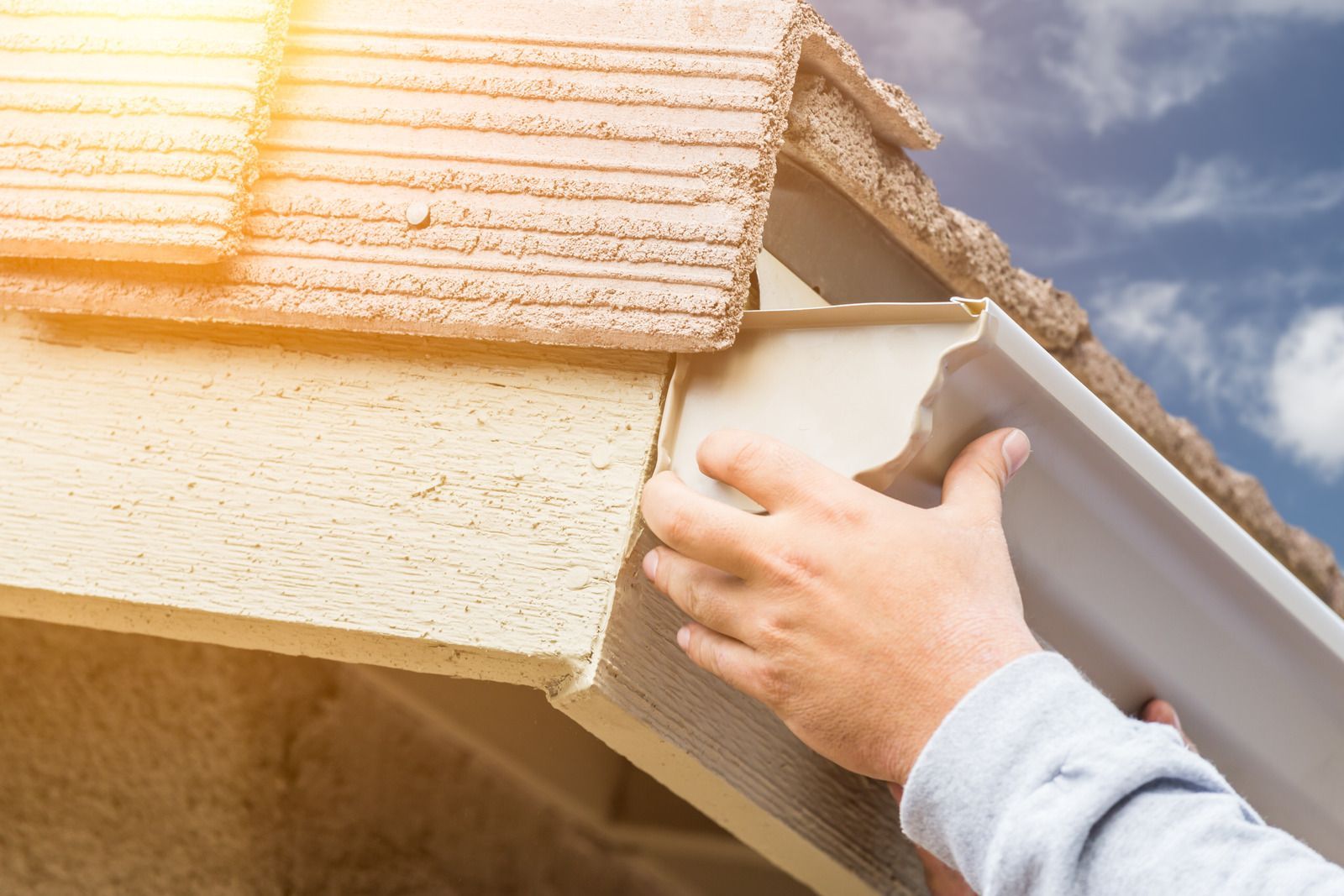 A man is working on the roof of a house.