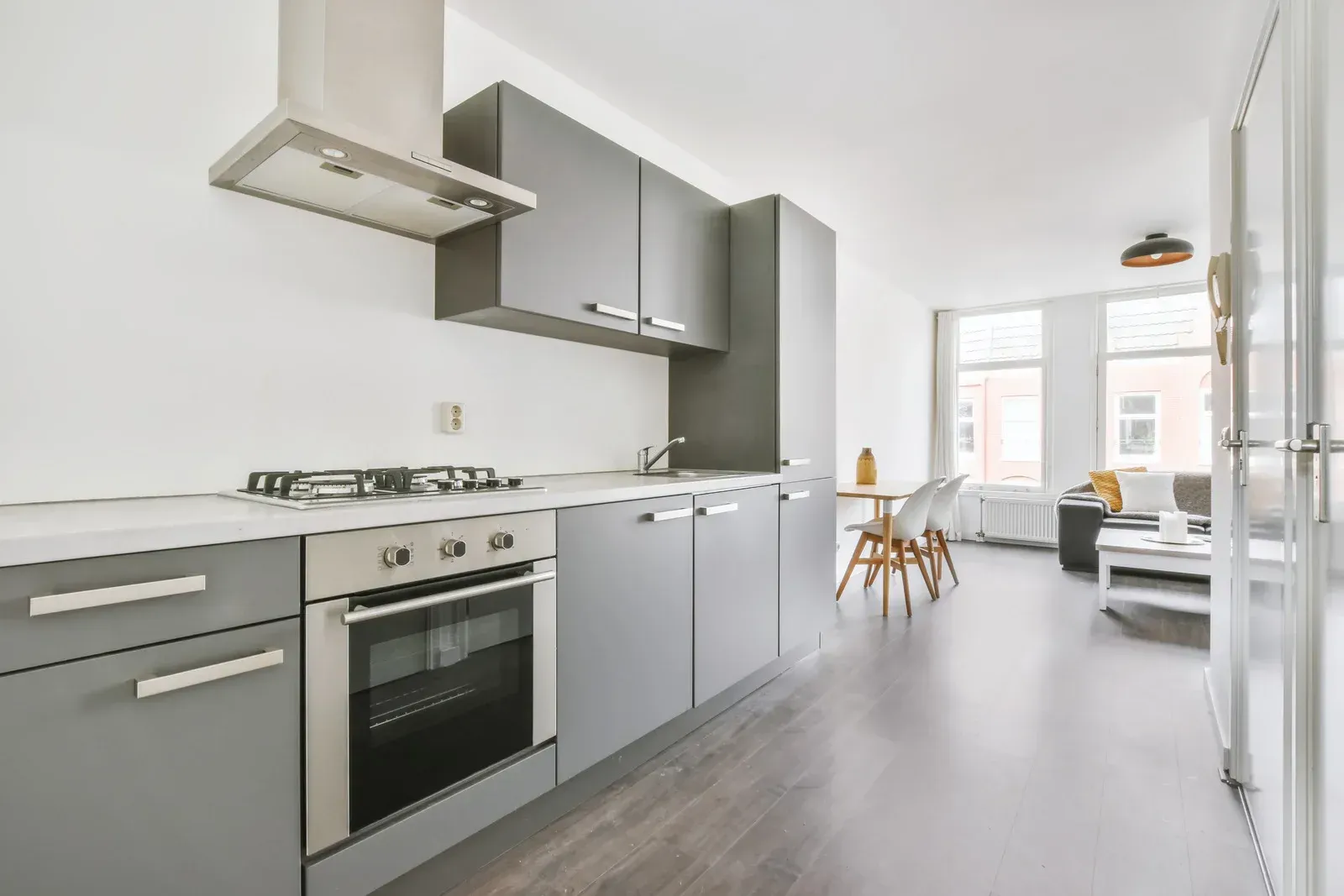 Gray modern kitchen with open living area.