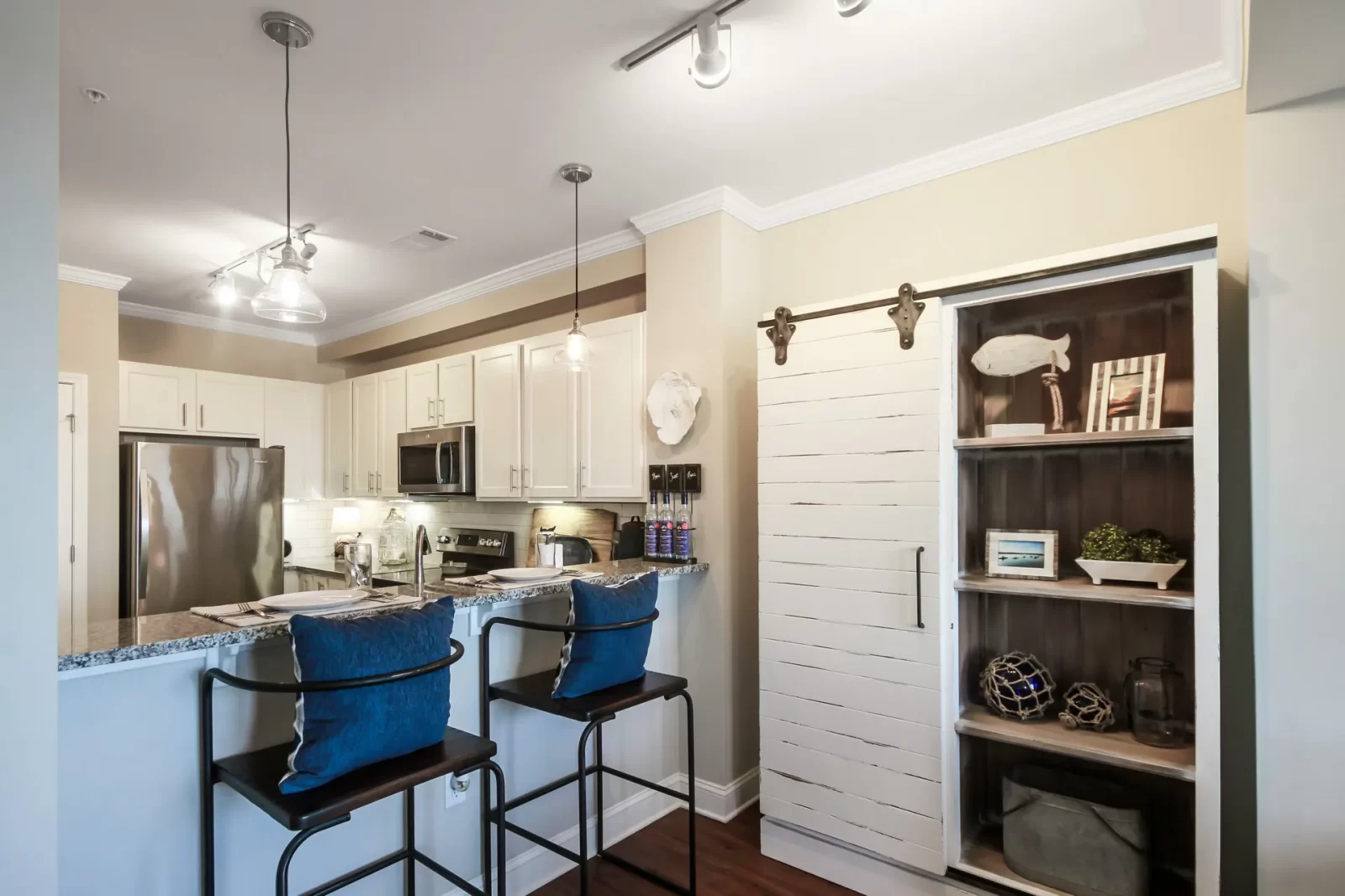 A kitchen with stools and a sliding barn door