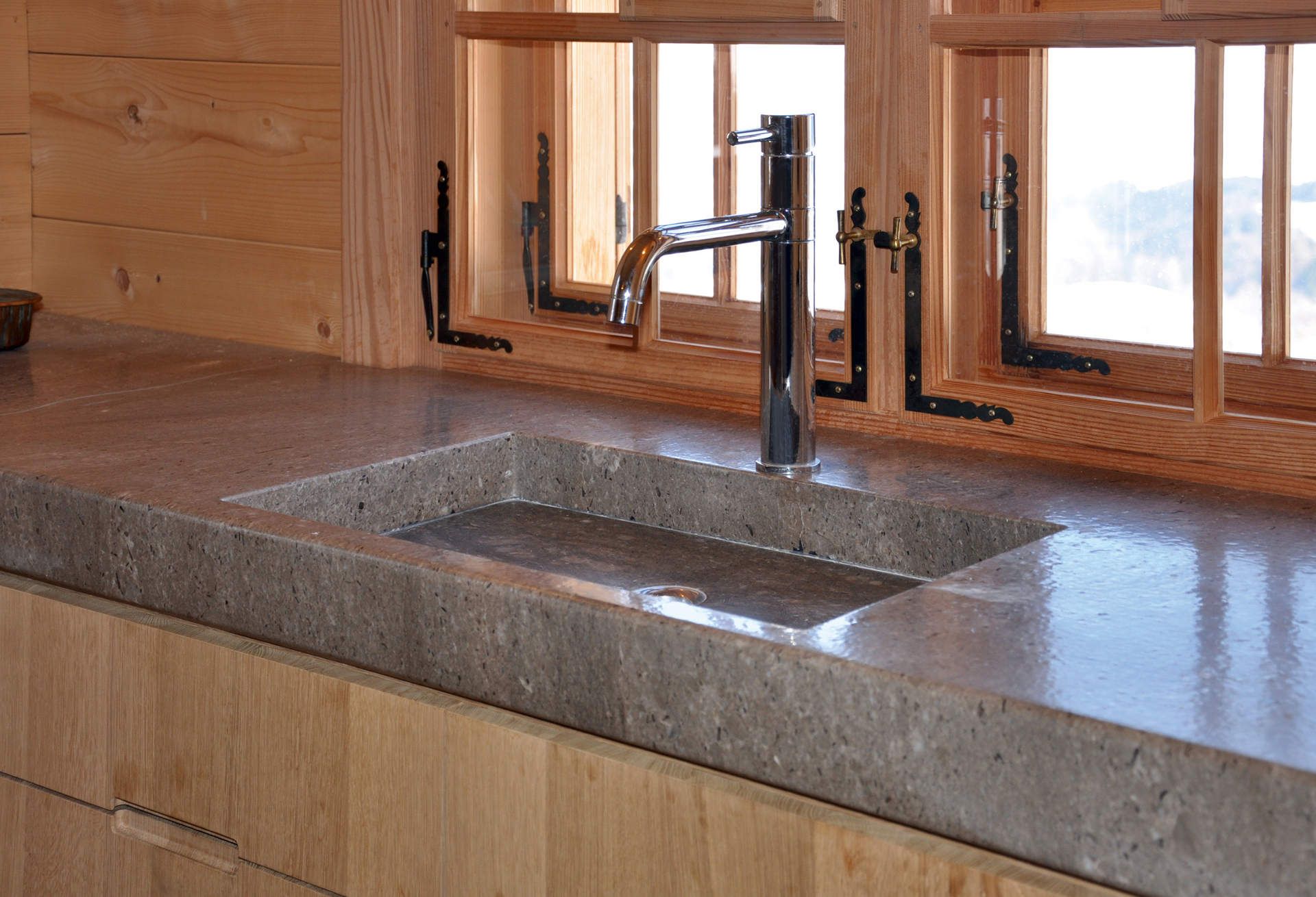 Eine Küchenspüle mit Wasserhahn und einem Fenster im Hintergrund