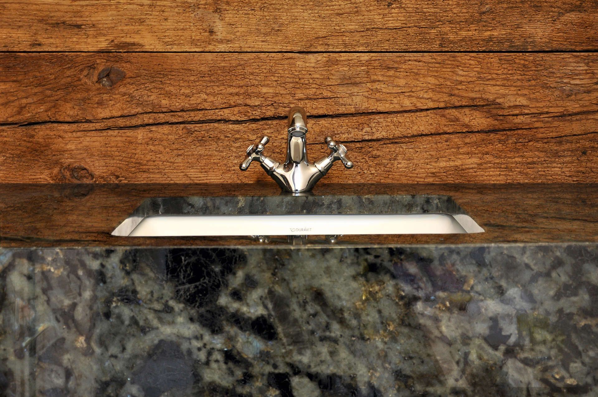 Ein Waschbecken mit Wasserhahn auf einer Holzarbeitsplatte.