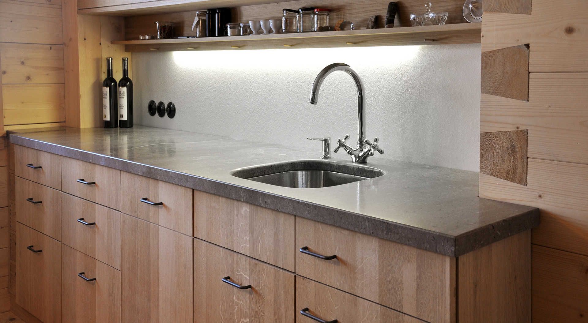 Eine Küche mit Holzschränken und einer Edelstahlspüle