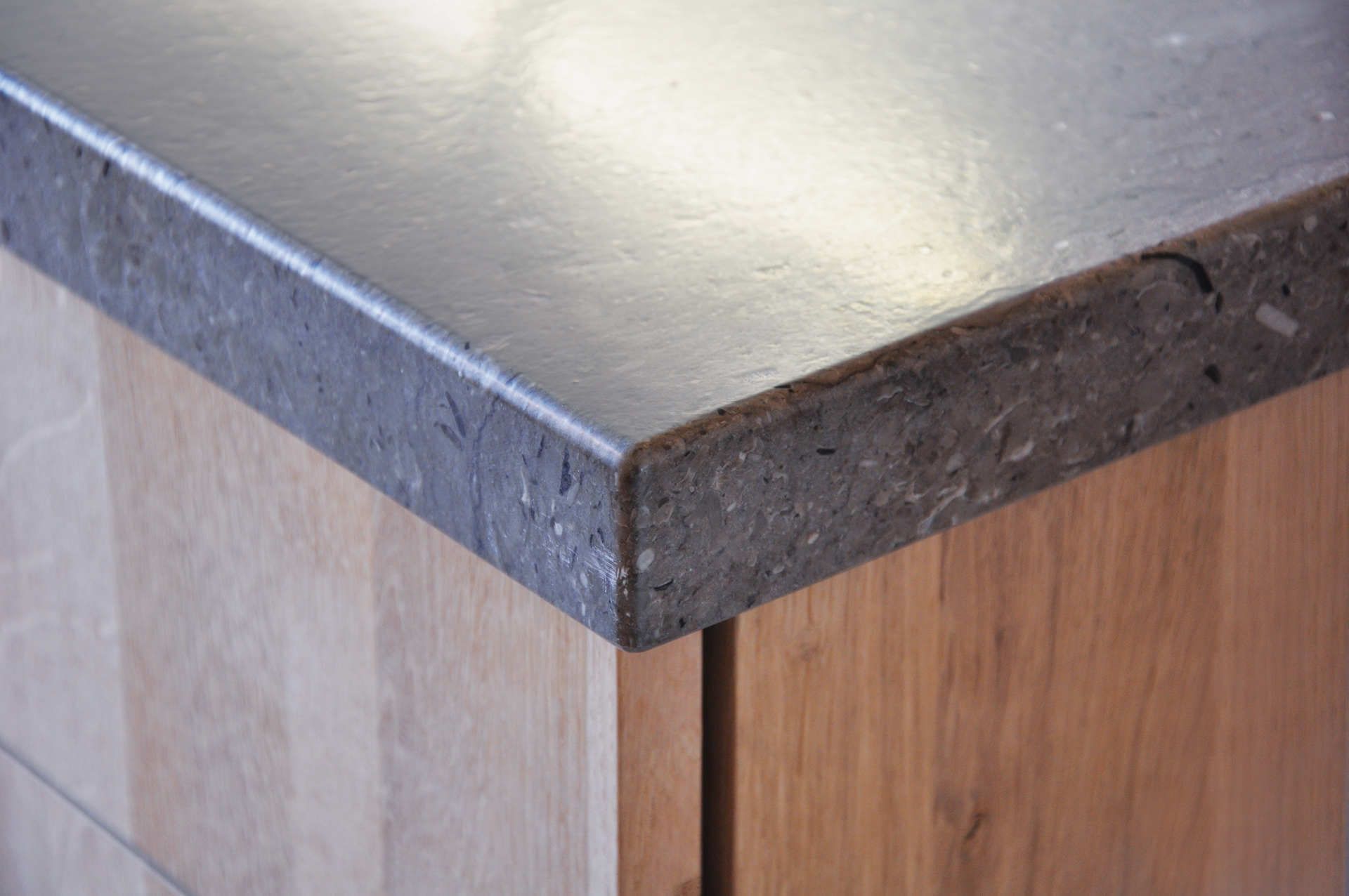 Eine Nahaufnahme einer Arbeitsplatte aus Edelstahl auf einem Holzschrank.