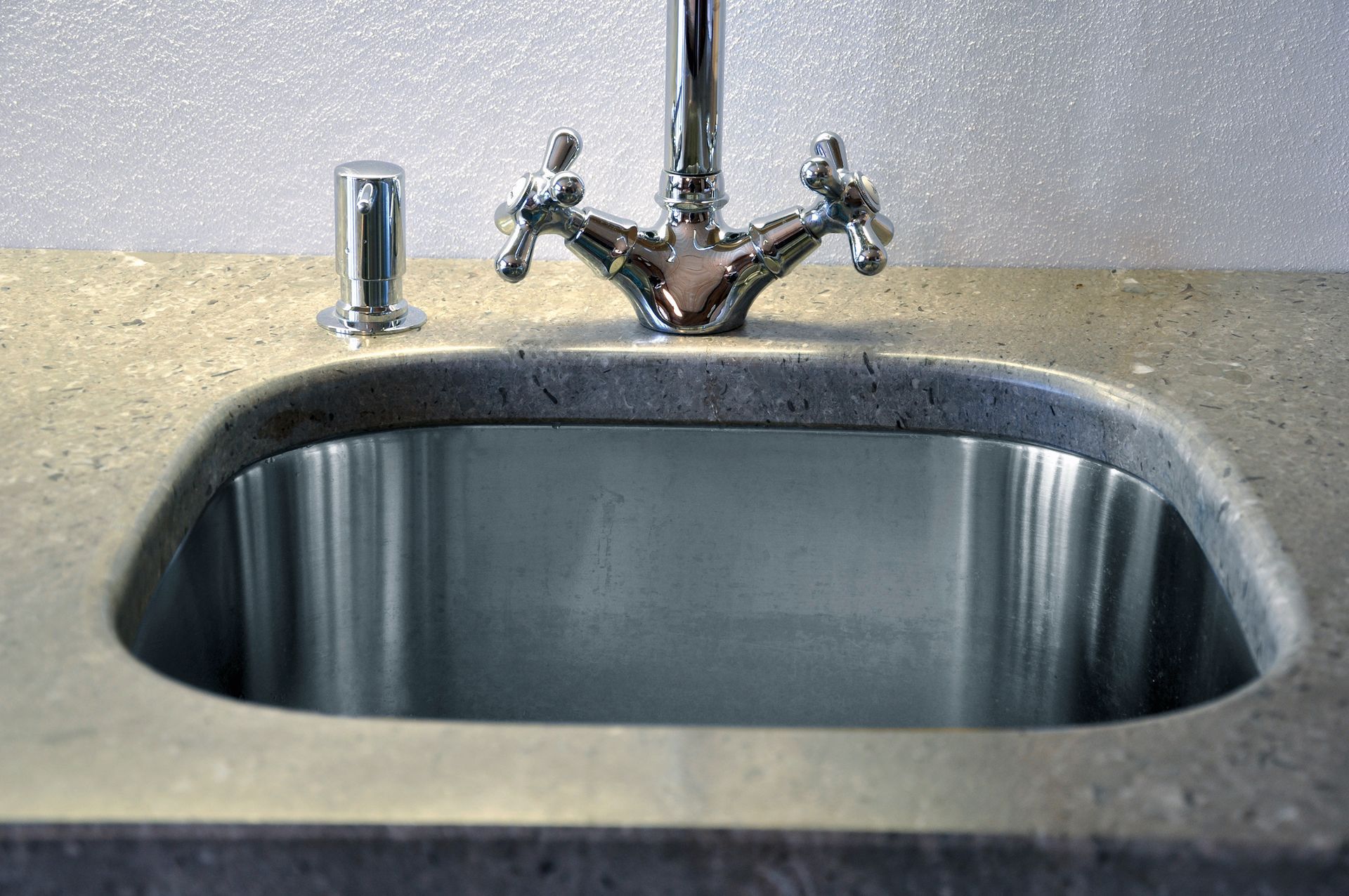 Eine Küchenspüle aus Edelstahl mit einem Chromhahn