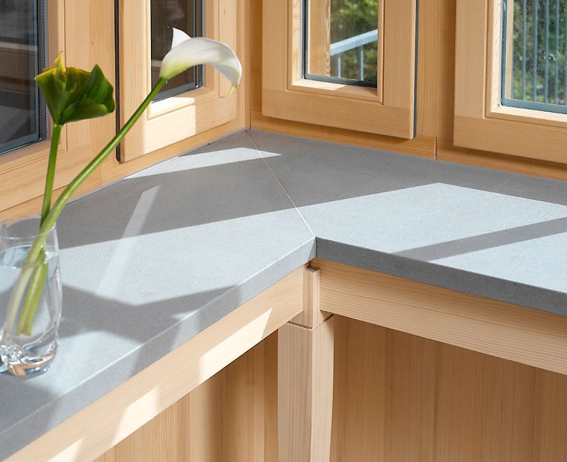 Ein Fensterbrett mit einer Vase mit Blumen darauf