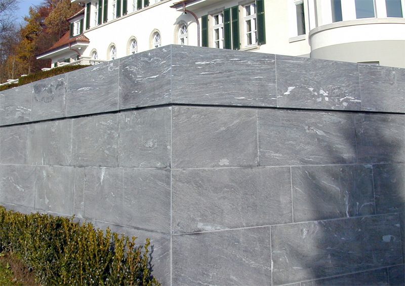 Ein großes Gebäude mit einer Backsteinmauer davor