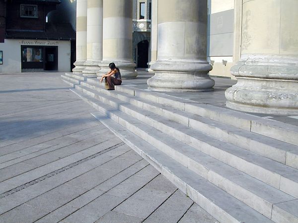 Eine Frau sitzt auf den Stufen eines Gebäudes