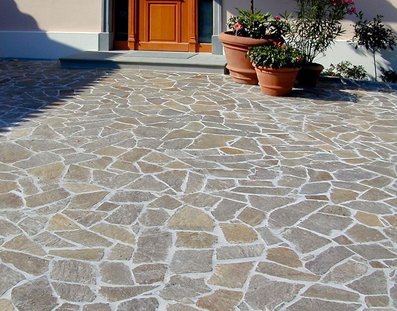 Ein Steinweg mit Topfpflanzen vor einem Haus