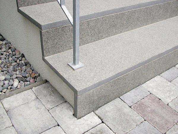 Eine Treppe mit einem Metallgeländer auf einem Gehweg.