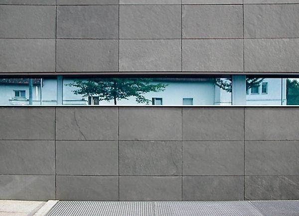 Ein Gebäude mit einem großen Fenster und einer Spiegelung eines Hauses