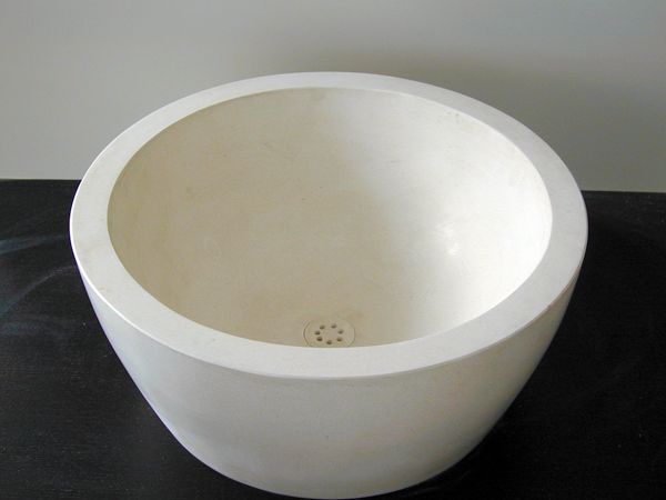 Eine weiße Schüssel mit einem Loch in der Mitte steht auf einem Tisch