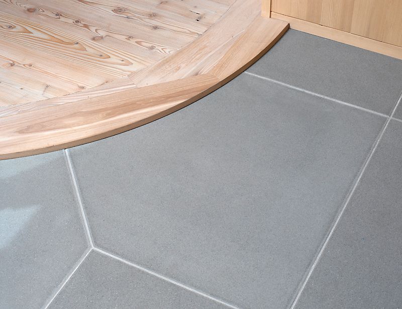 Ein gefliester Boden mit einem Holzboden im Hintergrund