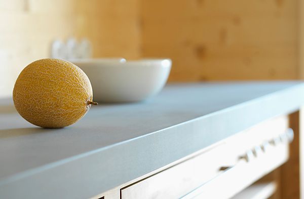 Auf einer Theke liegt neben einer Schüssel eine Zitrone.