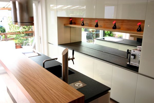 Eine Küche mit weißen Schränken und schwarzen Arbeitsplatten