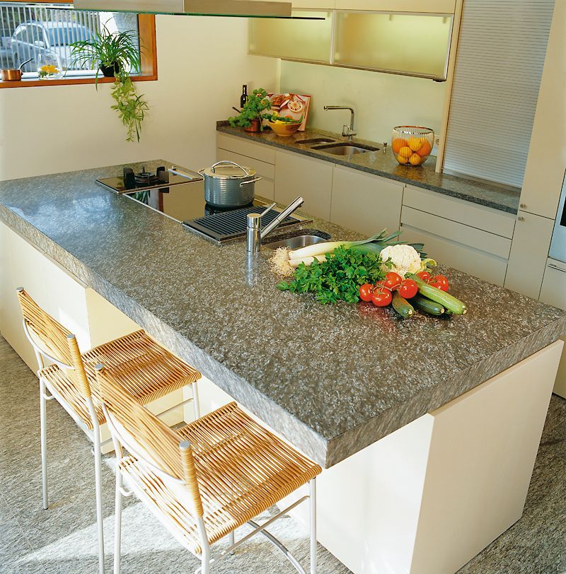 Eine Küche mit einer großen Insel mit Gemüse darauf