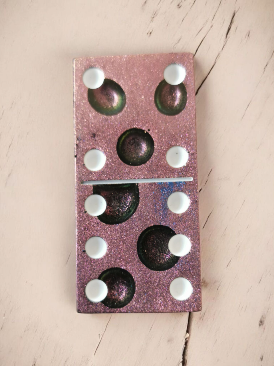 Glanzende roze en paarse dominosteen met witte stippen; toont de cijfers 6 en 2.